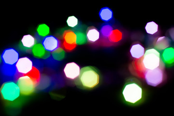 Christmas lights are lit on a black background. Copy the area for the top view text.