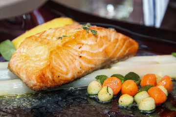 Grilled salmon steak garnished with vegetables and asparagus