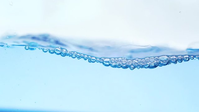 Blue water with bubbles slow motion.