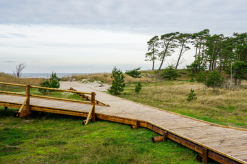 Fototapeta na wymiar a new wooden walkway and a resting place by the sea