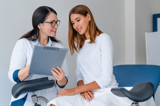 Adult smiling female gynecologist working with patient in modern clinic