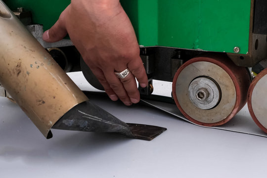 mechanism for laying and gluing sheets of roofing polymer. Adhesion of polymer roofing sheets.