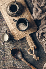Coffee on wooden board with coffee beans on dark textured background. Top view with copy space. Background with free text space.