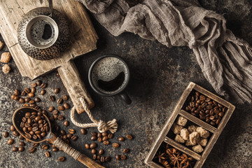 Coffee on wooden board with coffee beans on dark textured background. Top view with copy space. Background with free text space.