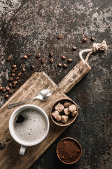 Coffee on wooden board with coffee beans on dark textured background. Top view with copy space. Background with free text space.