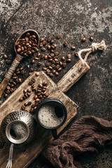 Coffee on wooden board with coffee beans on dark textured background. Top view with copy space. Background with free text space.