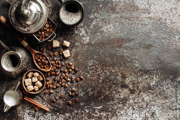Coffee cup with coffee grinder and coffee beans on dark textured background.