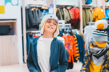 A boy choosing and picking right clothes in the store. Shopping and sales concept. Black friday and...