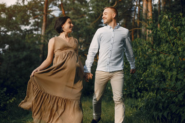 Pragnant woman. Family in a field. Man in a white shirt