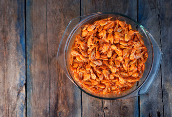 Beer snack. Tasty cooked shrimps in a plate on a wooden table.