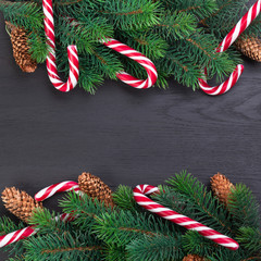 Christmas tree branch decorated with garlands, cones and caramel sticks