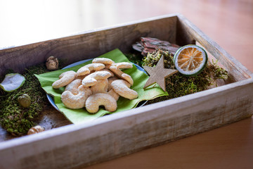 leckere vanillekipferl auf einem Tablett aus Holz mit Weihnachtsdekorationen