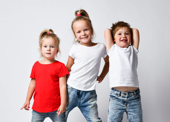 Happy funky kids girls and boy playing smiling with hands up in jeans. Happiness, childhood, freedom, movement