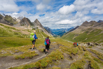 Fototapeta na wymiar Couple de randonneurs marchant dans une vallée en montagne