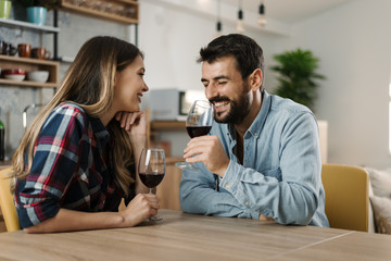 Young couple in love enjoying in conversation while drinking red wine