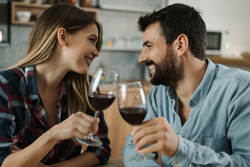 Young couple in love enjoying in conversation while drinking red wine