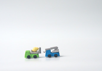 The blue crane truck and green concrete mixer truck are isolated on white background.
