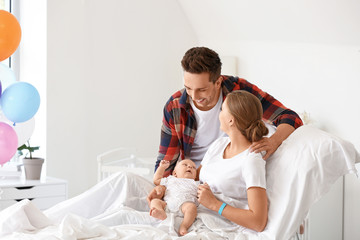 Young family with newborn baby in maternity hospital