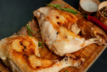 Two fried chicken legs on a stone background with spices, ready to eat