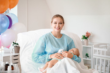 Fototapeta premium Young mother with newborn baby in maternity hospital