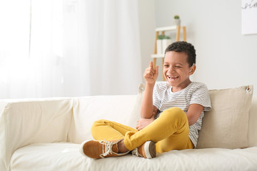 Laughing African-American boy with hearing aid at home