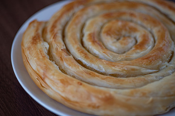 Spiral Snail shaped Greek Cheese pie (Kichi Kozanis) close up view.