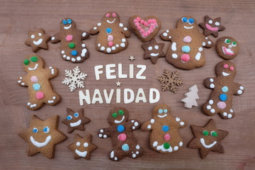 Feliz Navidad, spanish Merry Christmas message with gingerbread cookies and a creative text with wooden letters 