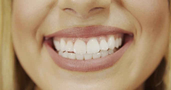 Close up of smile with white healthy teeth. Beautiful wide smile of young fresh woman with great healthy white teeth. Select 4K.