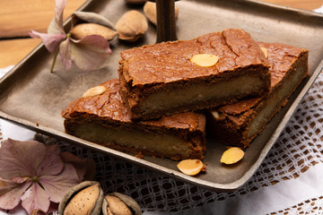 Fresh baked Dutch filled spicy cookies with almonds in autumn colors on dark wooden background