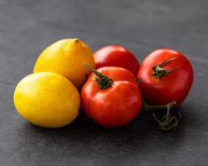 colorful tomatoes and lemons in gray background