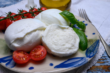 Cheese collection, organic mozzarella soft cheese served with ripe tomato and fresh green basil