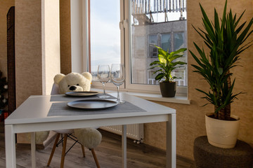 interior of a bright room with a white dining table, chairs and indoor flowers
