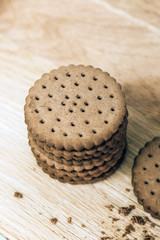 Crispy chocolate chip cookie with holes on a wooden board. Filled Round Cookies
