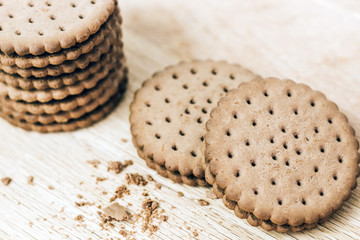 Crispy chocolate chip cookie with holes on a wooden board. Filled Round Cookies