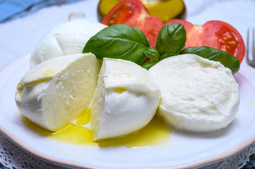 Cheese collection, organic mozzarella soft cheese served with ripe tomato and fresh green basil