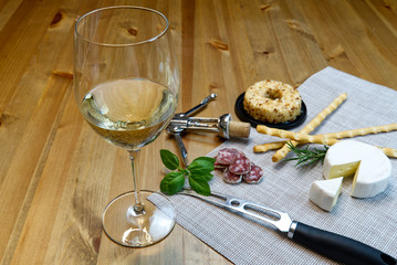 Cheese appetizer selection or Cheese and wine party table. Brie cheese, bread sticks and salami is great appetizer tostart your dinner.
