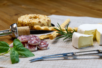 Cheese appetizer selection or Cheese and wine party table. Brie cheese, bread sticks and salami is great appetizer tostart your dinner.