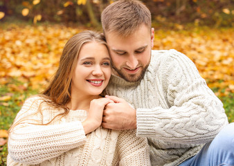 Fototapeta premium Autumn romance and couple bonding, young man and woman embracing outdoors with fall leaves