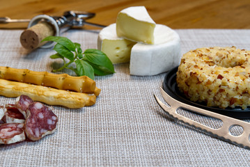 Cheese appetizer selection or Cheese and wine party table. Brie cheese, bread sticks and salami is great appetizer tostart your dinner.