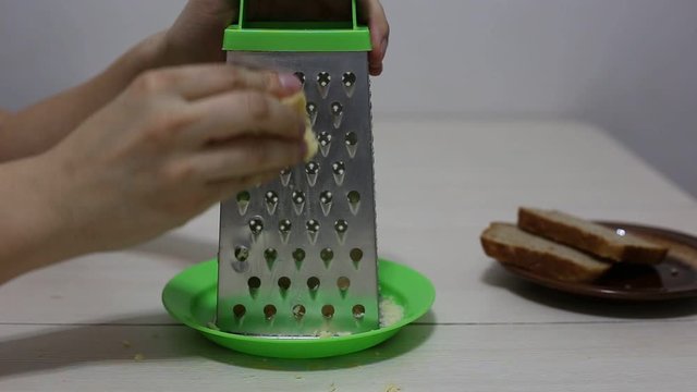 Hands grating cheese. Close-up footage.