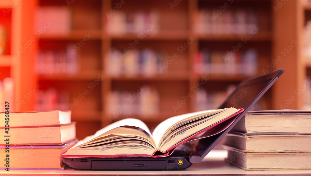 Poster Stack of books in the library and blur bookshelf background