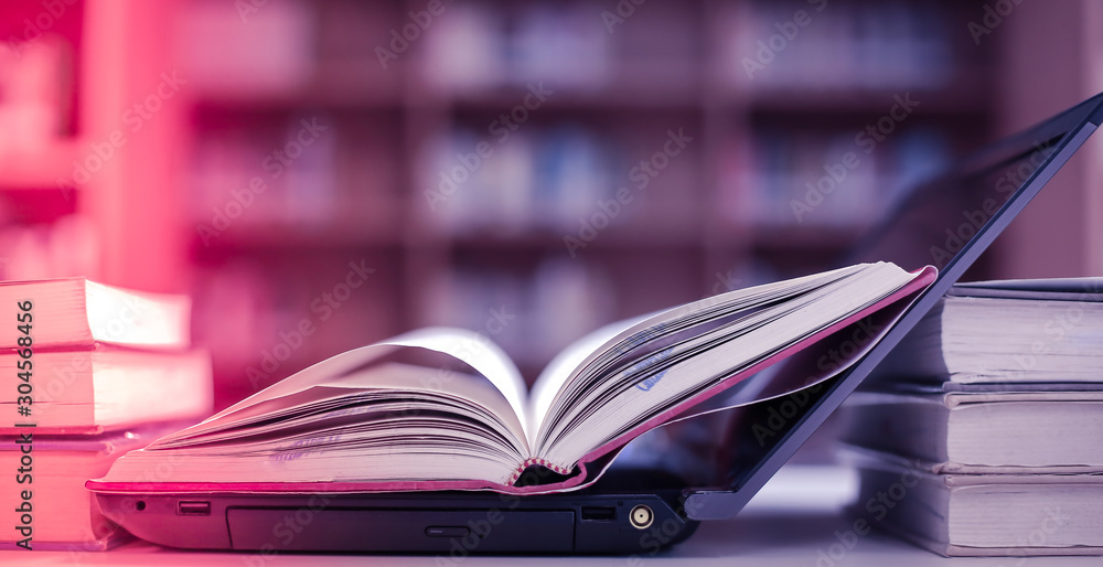 Poster Stack of books in the library and blur bookshelf background