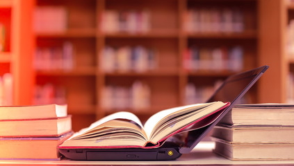 Stack of books in the library and blur bookshelf background