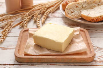 Tasty butter and bread on table