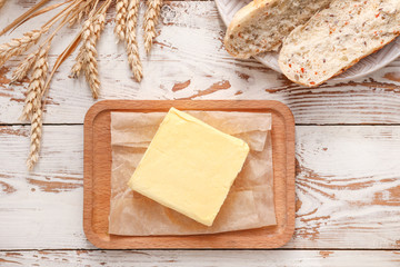 Composition with tasty butter and bread on table