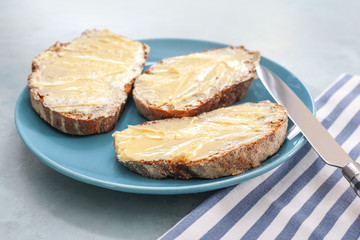 Tasty bread with butter on plate
