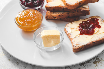 Sweet toasts with butter and jam on plate