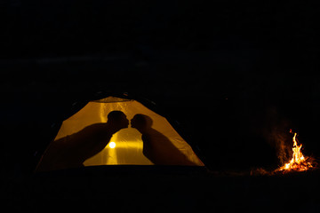 Fototapeta na wymiar Shadow of a couple in love kisses in a tourist tent in nature. camping in the wilderness