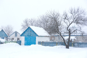 Old rural house. Snow blizzard. A lot of snow