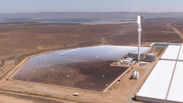 Solar thermal power plant which uses mirrors to heat salt in the tower. Molten salt is used to generate steam power. Green renewable energy and global warming concepts.